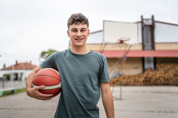 One caucasian teenager stand on basketball court with ball