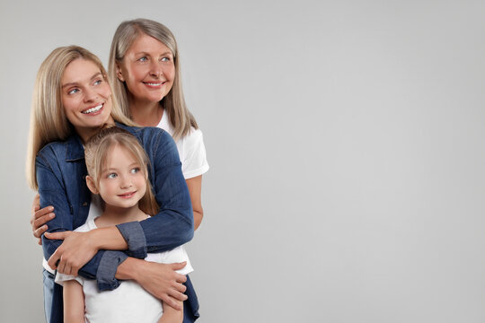 Three Generations. Happy Grandmother, Her Daughter And Granddaughter On Light Gray Background, Space For Text