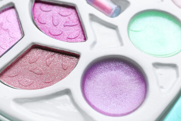 Decorative cosmetics for kids. Eye shadow palette as background, closeup