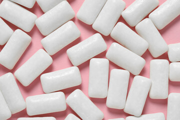 Tasty white chewing gums on pink background, flat lay