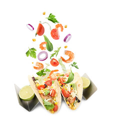Delicious tacos. Ingredients falling into tortillas on white background