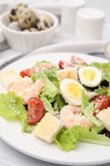 Delicious Caesar salad with shrimps on table