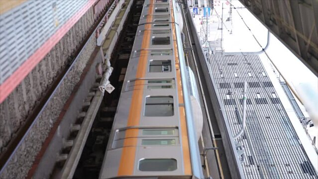 Young Asian woman in winter coat waiting for the trai in Japan. Attractive girl traveler enjoy outdoor lifestyle travel Japan by railroad transportation on winter holiday vacation.