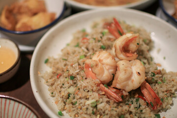 Fried rice with shrimp on white plate. Quick and healthy Asian meal. Made from fresh shrimps, lime and vegetables.