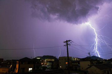 Thunderstorms falling on the city with purple light.