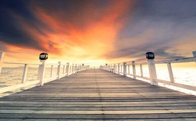 beautiful wood pier against dramatic sunset sky