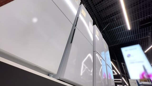 New refrigerators lined up in a home appliance store. Extreme wide low angle view