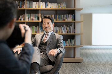 Image of a president or professor being interviewed, etc. with a smile. Photographer's front...