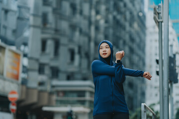 Glad smiling young asian muslim woman in hijab with fitness tracker running on building background outdoor. Fitness outside, jogging in morning, body and health care, training, concept muslim sport.