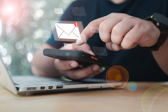 Hand of a man using a smartphone for an email with notification alert flying from smart phone