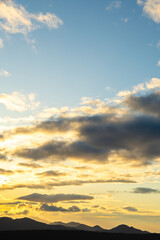 Obraz premium 山のシルエットの上の朝焼けの空と雲。