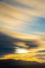 山のシルエットの上の朝焼けの空と雲。