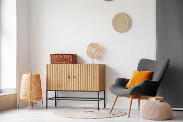 Interior of stylish living room with wooden cabinet and cozy armchair