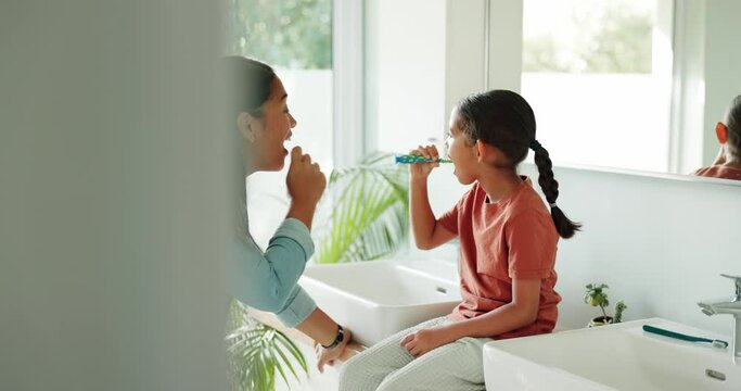 Mother, teaching or kid in bathroom brushing teeth together for learning or child development at family home. Morning, happy mom or girl cleaning mouth with toothbrush or toothpaste for dental health