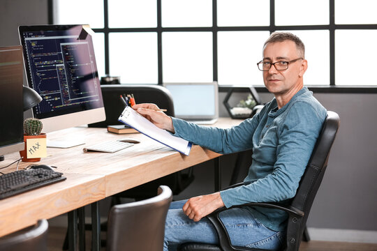 Mature male programmer working in office