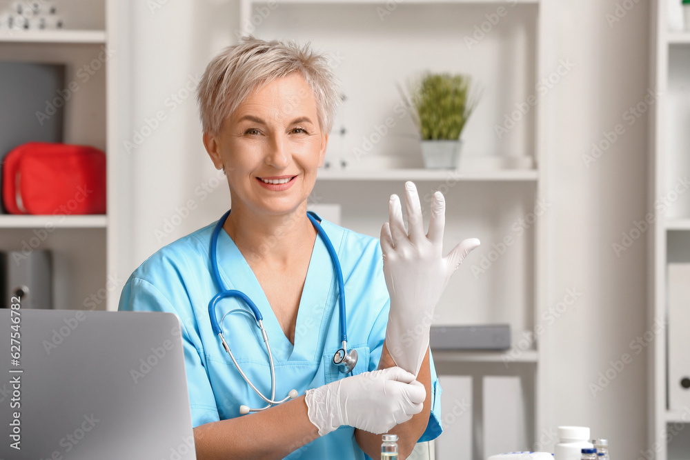 Canvas Prints Female doctor putting medical gloves in clinic