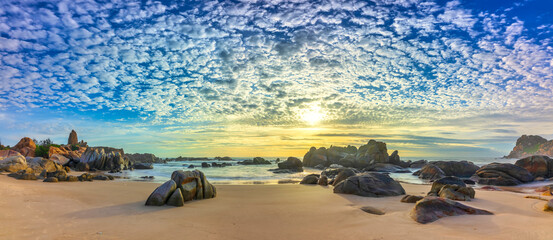 Dawn on the beach brightly colored clouds, beneath a rock with beautiful shapes create beautiful scenery welcome bright day fresh © huythoai