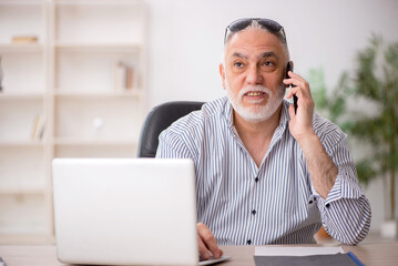 Old male employee working in the office