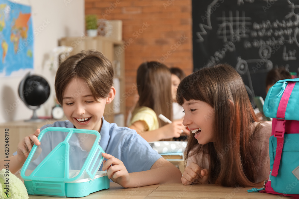 Sticker Little pupils with backpack and lunchbox sitting in classroom