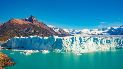 Panoramic over big Perito Moreno glacier in Patagonia with blue sky and turquoise water glacial lagoon, South America, Argentina, in Autumn colors - obrazy, fototapety, plakaty