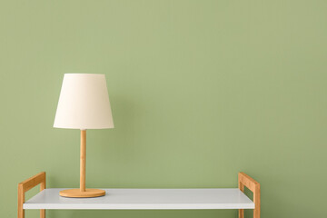 table lamp on white shelf near green wall