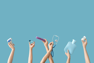 Female hands with medical tools and pills on blue background