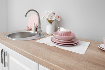 Kitchen counter with clean dishes, sink and orchid flowers