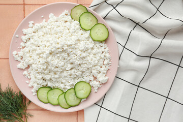 Plate with cottage cheese and cucumber slices on tiled table