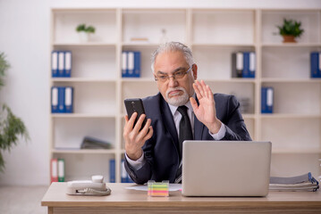 Old male employee working in the office