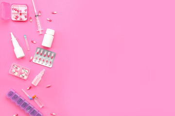 Composition with pills, syringe and ampules on pink background