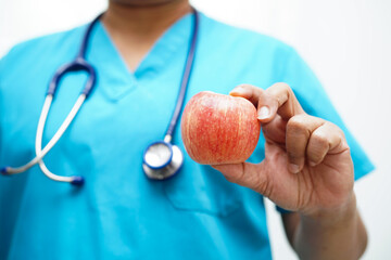 Asian Nutritionist holding apple healthy food for patient in hospital, nutrition and vitamin.