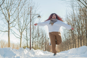 Smiling chubby redhead woman running in park in winter.