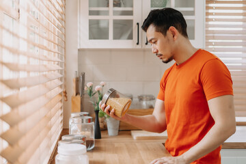 Asian man calm in the kitchen in the morning prepare his easy breakfast.