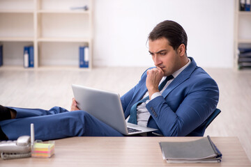 Fototapeta premium Young male employee working in the office