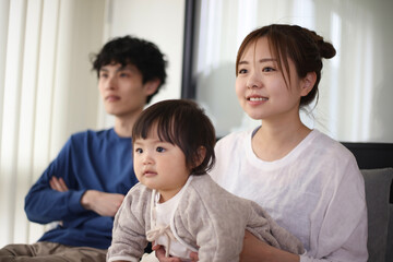 Obraz premium テレビでスポーツ観戦する家族