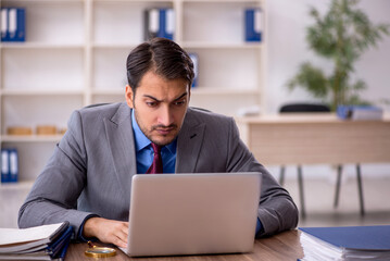 Fototapeta premium Young male employee working in the office