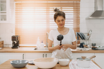 Portrait of happy asian woman preparing breakfast in the kitchen in the morning.