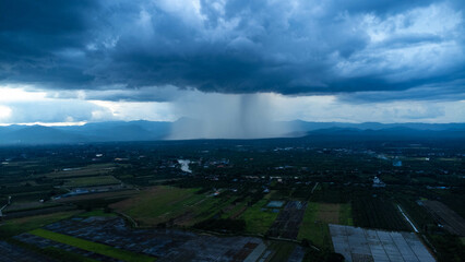 Aerial panoramic view of community and farmland with huge storm clouds in the background. Aerial view of the rain over a rural community. Rain clouds shot from a drone.