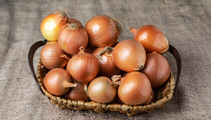 A lot of onions in a basket on a textural background. Vegetables in a basket in the form of onions. Harvest onions on burlap.