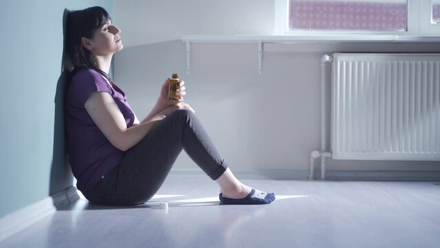 The woman who looks at the pills in her hand and is going to commit suicide.