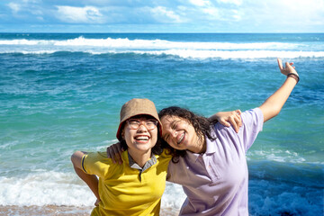 Two Asian women with an excited expression traveling on the beach
