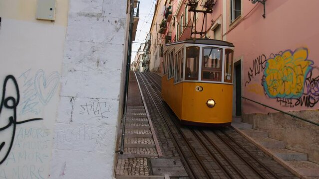 Bica Funicular Moving Uphill Through Buildings In Lisbon, Portugal. low angle, wide