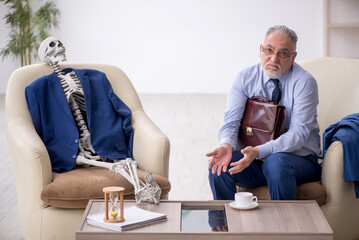 Old businessman meeting with skeleton in business meeting concep