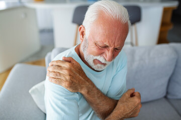 Senior elderly man touching his shoulder, suffering from shoulder pain, sciatica, sedentary...