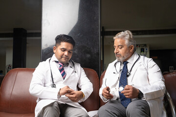 Indian Senior doctor talking with junior doctor.