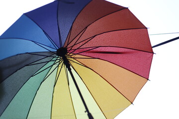 Colorful rainbow umbrella opened on a white background