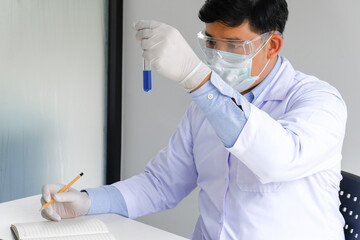Science innovative Male medical or scientific laboratory researcher performs tests with blue liquid...
