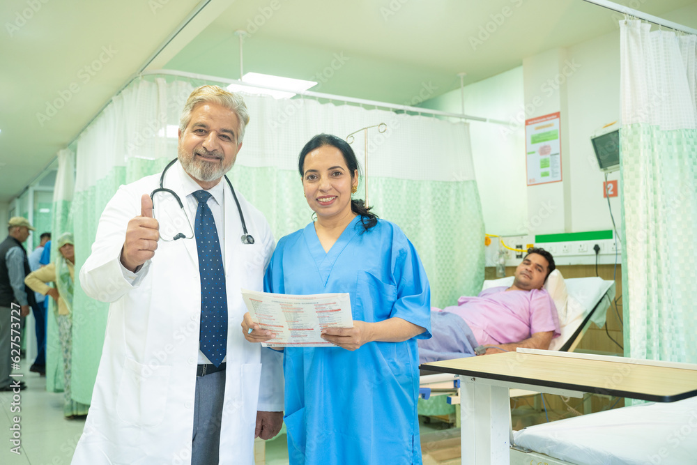 Wall mural Doctor showing thumps up at hospital.