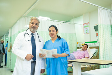 Obraz premium Senior doctor discussing with female assistant after checking patient at hospital