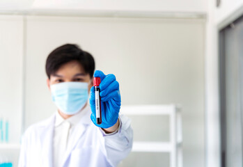 Scientist man holding sample blood test tube in science laboratory. Doctor clinic healthcare...